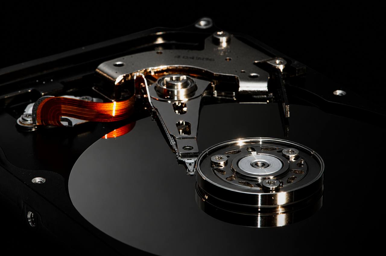 Close-up mechanical hard drive platter and actuator arm.